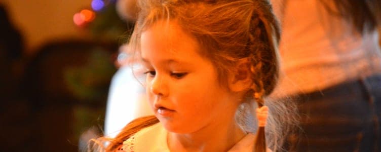 A young student having her hair braided at a school gathering
